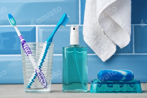 Preview: The toothbrushes in a glass in blue bathroom