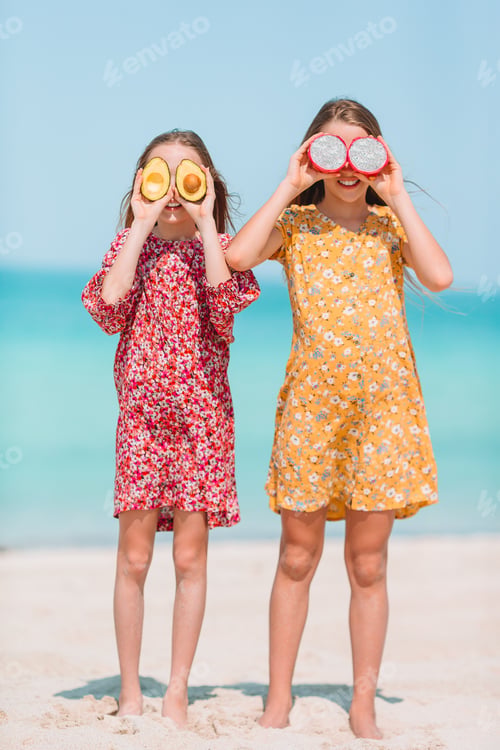 Preview: Little happy funny girls have a lot of fun at tropical beach playing together