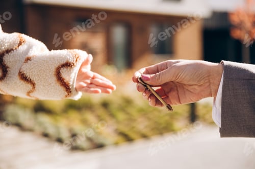 Preview: Real estate agent handing house keys to new homeowner elective focus on hands