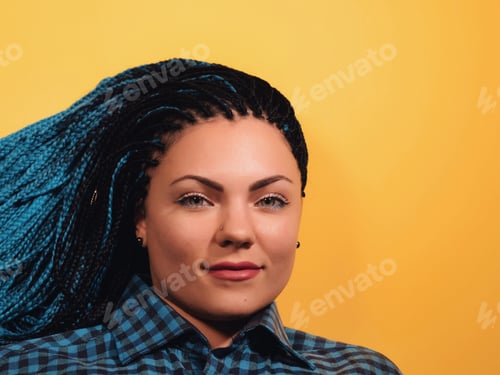 Preview: Beautiful young girl with african blue braids looks at the camera