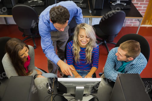 Preview: High Angle View Of Teacher Showing Something On Screen To Students In The Computer Room