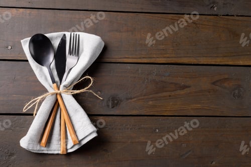 Preview: Overhead view of cutlery, rustic string and napkin with copy space on wooden background