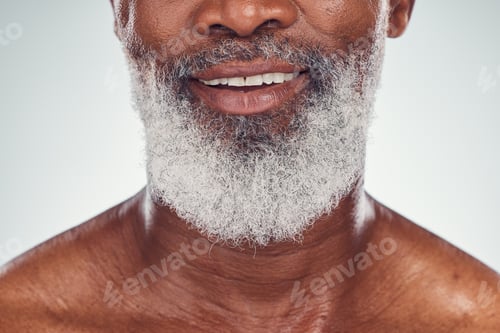 Preview: Smile, beard and face with a senior black man grooming in studio on a gray background for beauty or