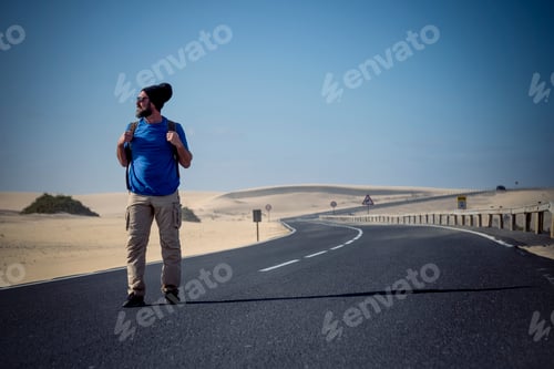 Preview: Coloured image of people man with travel backpack walking in the middle of the road