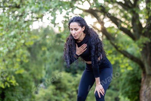 Preview: Portrait of a beautiful female athlete in the park, Hispanic woman rests and breathes during