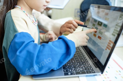 Preview: of Schoolgirl Pointing at Computer Screen Working on Online Assignment