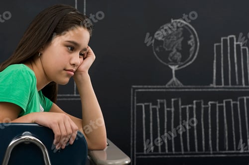 Preview: Young student lost in thought with chalkboard graphs in the background.