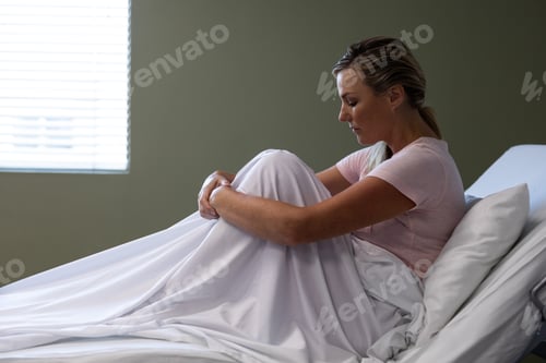 Preview: Portrait of caucasian female patient sitting on hospital bed in patient room