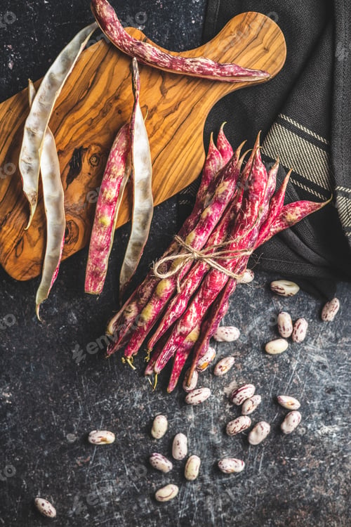 Preview: Cranberry beans. Beans pods on black table.