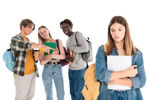 Preview: Selective focus of multiethnic teenagers smiling near sad girl with notebook isolated on white