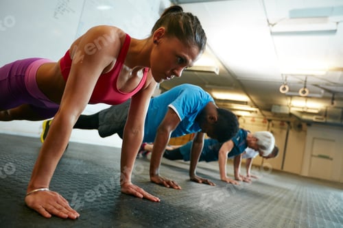 Preview: Working the upper body. Shot of a group of people working out in the gym.
