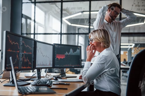 Preview: Two stockbrokers in formal clothes works in the office with financial market