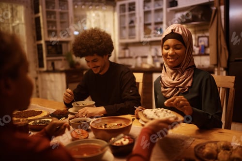 Preview: Happy Middle Eastern family enjoying in dinner at dining table.