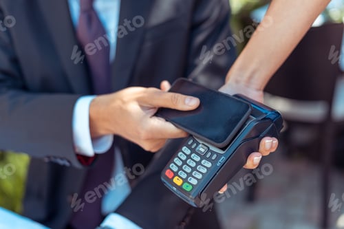 Preview: Close-up view man paying with NFC technology on smartphone