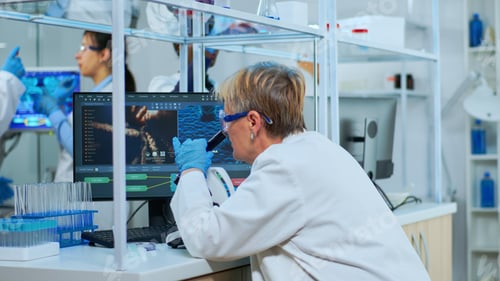 Preview: Senior scientist looking through a microscope in a laboratory
