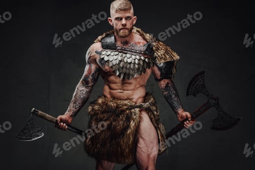 Preview: Brutal tattooed warrior wearing light armour and fur holding axes in dark studio