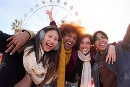 Preview: Happy multiethnic group of friends taking a photo at amusement park, looking at camera smiling.