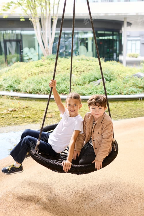 Preview: Two joyful children enjoy swinging on a cozy autumn day full of laughter and friendship
