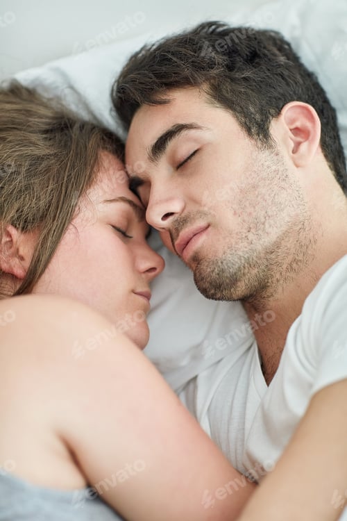 Preview: Sharing the moments that matter. Shot of a relaxed young couple sleeping in bed together at home.