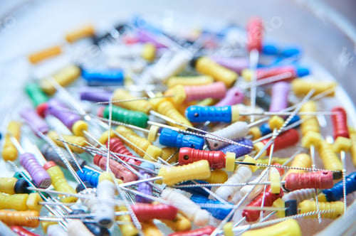 Preview: A colorful assortment of dental endodontic files used for root canal treatments. Close-up of medical