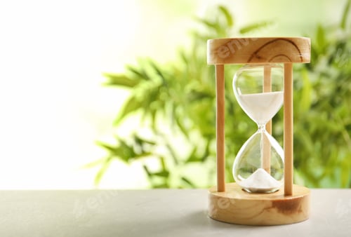 Preview: Hourglass with flowing sand on table against blurred background. Time management