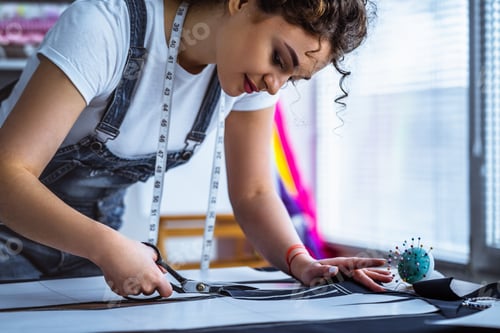 Preview: The beautiful tailor sews a dress on the table