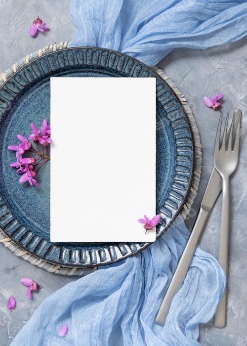 Preview: Wedding table place with a card near fabric and wild purple flowers top view on gray, spring mockup