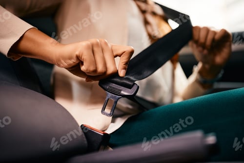 Preview: Close-up of female driver fastening seatbelt while driving car.