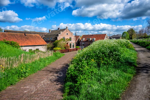 Preview: A village scene with traditional brick houses, lush greenery, and a clear blue sky.