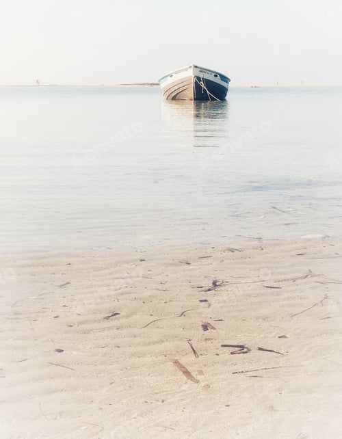 Tranquil Boat on Still Water Near Sandy Beach