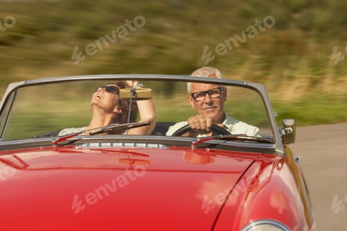 Preview: Mid aged couple in sports car