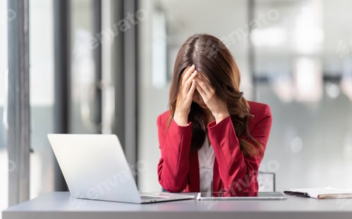 Preview: business woman stressed ,suffering headache or migraine with laptop computer and papers working
