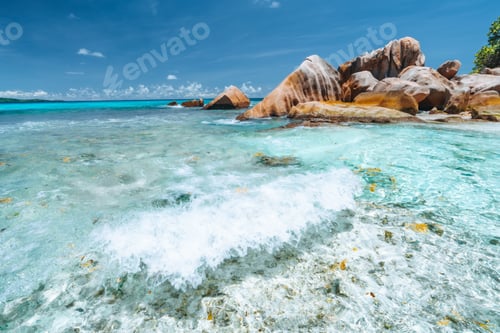 Preview: Waves of Anse Cocos at la Digue island, Seychelles. Secluded beautiful tropical beach with rocks in