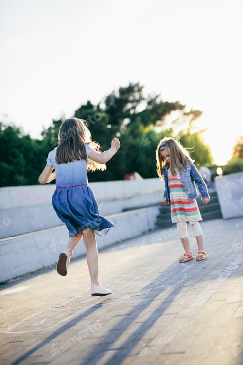 Preview: Kids jumping playing hopscotch in urban neighborhood