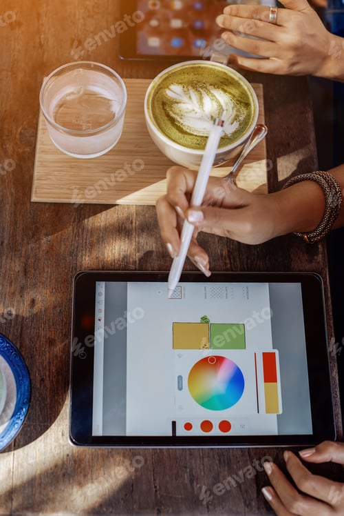 Preview: Two female designers work using a tablet and speical program outdoors
