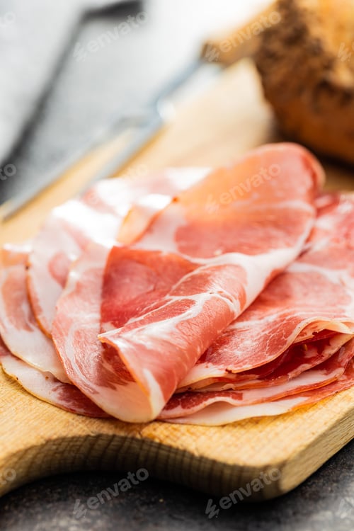 Preview: Italian dried ham. Coppa Stagionata on cutting board.