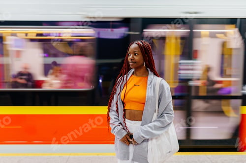 Preview: Woman standing in metro with moving train behind