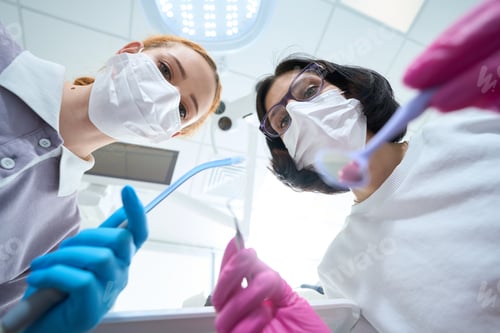 Preview: Two women in protective masks in process of dental manipulation