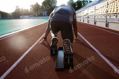 Preview: Back view of a young male athlete at starting block