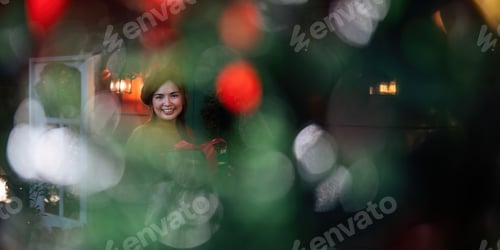 Preview: Happy woman wearing Santa hat holding of gift box. Positive emotional Santa girl. with a