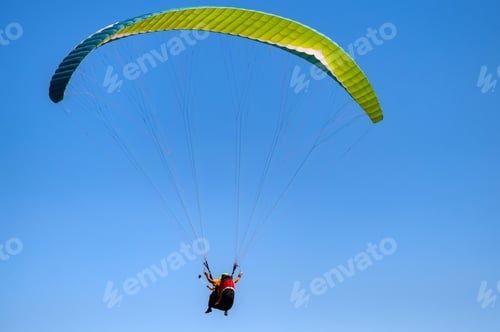 Preview: Cloudless photo of two people paragliding in blue sky