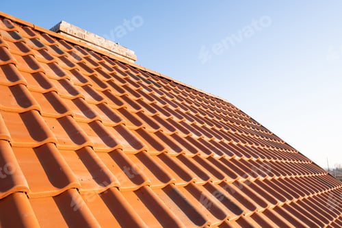 Preview: Overlapping rows of yellow ceramic roofing tiles covering residential building roof