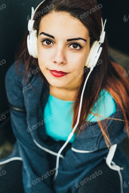 Preview: Woman with Headphones Smiling and Looking Upward