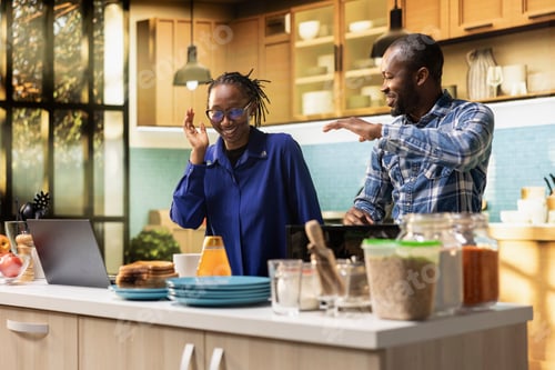 Preview: Black couple doing dance moves and laughing in their bright kitchen