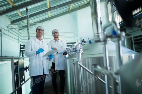 Preview: Portrait of scientists with clipboard standing by storage tank