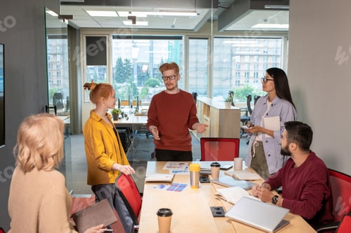 Preview: Young broker explaining his point of view or business strategy to colleagues