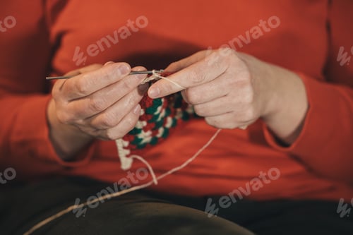 Preview: Woman crocheting colorful wool granny square indoors