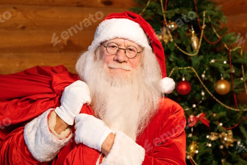 Preview: Santa in traditional costume, white gloves and eyeglasses carrying big red sack