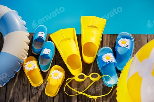 Preview: Beach flip-flops and sunglasses on wooden planks near swimming pool