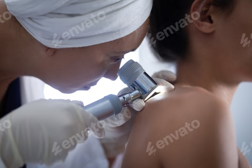 Preview: Female doctor checking the body of female patient with dermatoscopy in a clinic